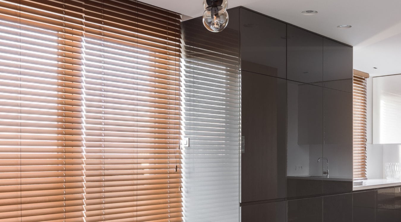 Non-natural colored window treatments will look outdated after a while. Warm wooden blinds in a window